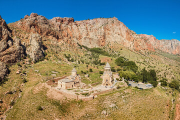 Naklejka premium Aerial view of famous Noravank monastery with two churches located in a picturesque mountain gorge with red rocks. Popular place and travel excursions in Armenia