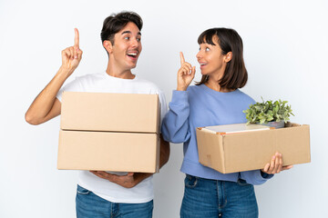 Young couple making a move while picking up a box full of things isolated on white background...