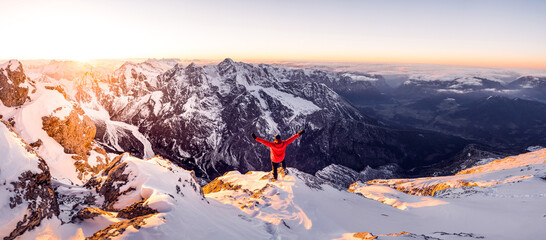 Hiker on a summit in a wintry mountain landscape. Climber on a summit freedom