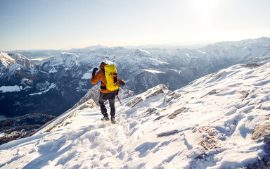 Fototapeta na wymiar Beautiful amazing day winter mountains. A man goes a sport hike in snow holidays. Nature background
