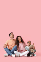 Happy interracial family looking at something on color background