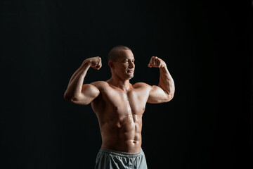 Fototapeta na wymiar Male bodybuilder on dark background