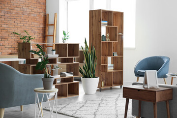 Stylish bookshelves with houseplants in living room