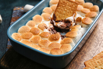 Baking dish with tasty S'mores dip on table, closeup