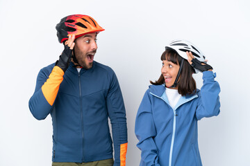 Young cyclist couple isolated on white background with surprise and shocked facial expression