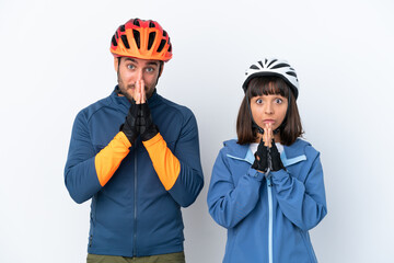 Young cyclist couple isolated on white background keeps palm together. Person asks for something