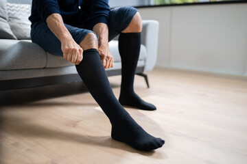 Man Putting On Medical Compression Stockings