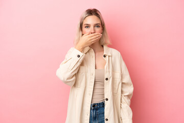 Young caucasian woman isolated on pink background covering mouth with hand