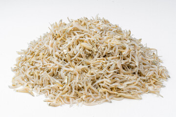 Fresh dried anchovies on White Background. Raw dry salted sea fish. saltwaterforage fish. Ikan asin teri medan.