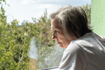 sad senior woman female alone home closeup depressed coronavirus isolation widower unhappy...