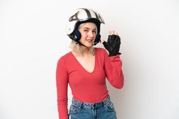 Young caucasian woman with a motorcycle helmet isolated on white background saluting with hand with happy expression