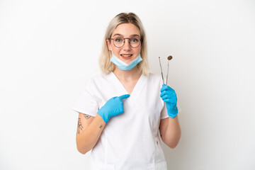 Dentist caucasian woman holding tools isolated on white background with surprise facial expression