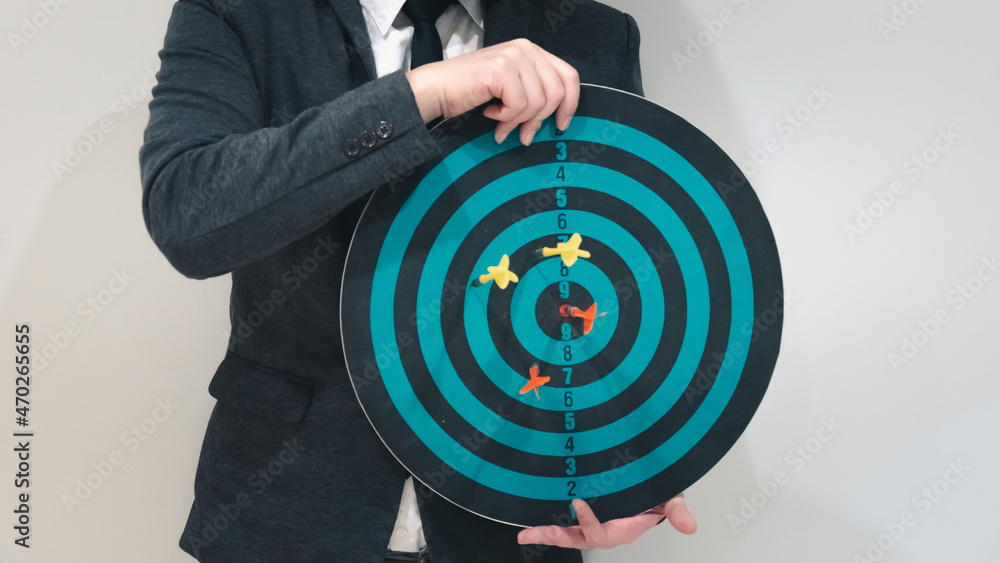 Poster close up shot of the dart arrow hit on bulleyes of dartboard to represent that the business reached 