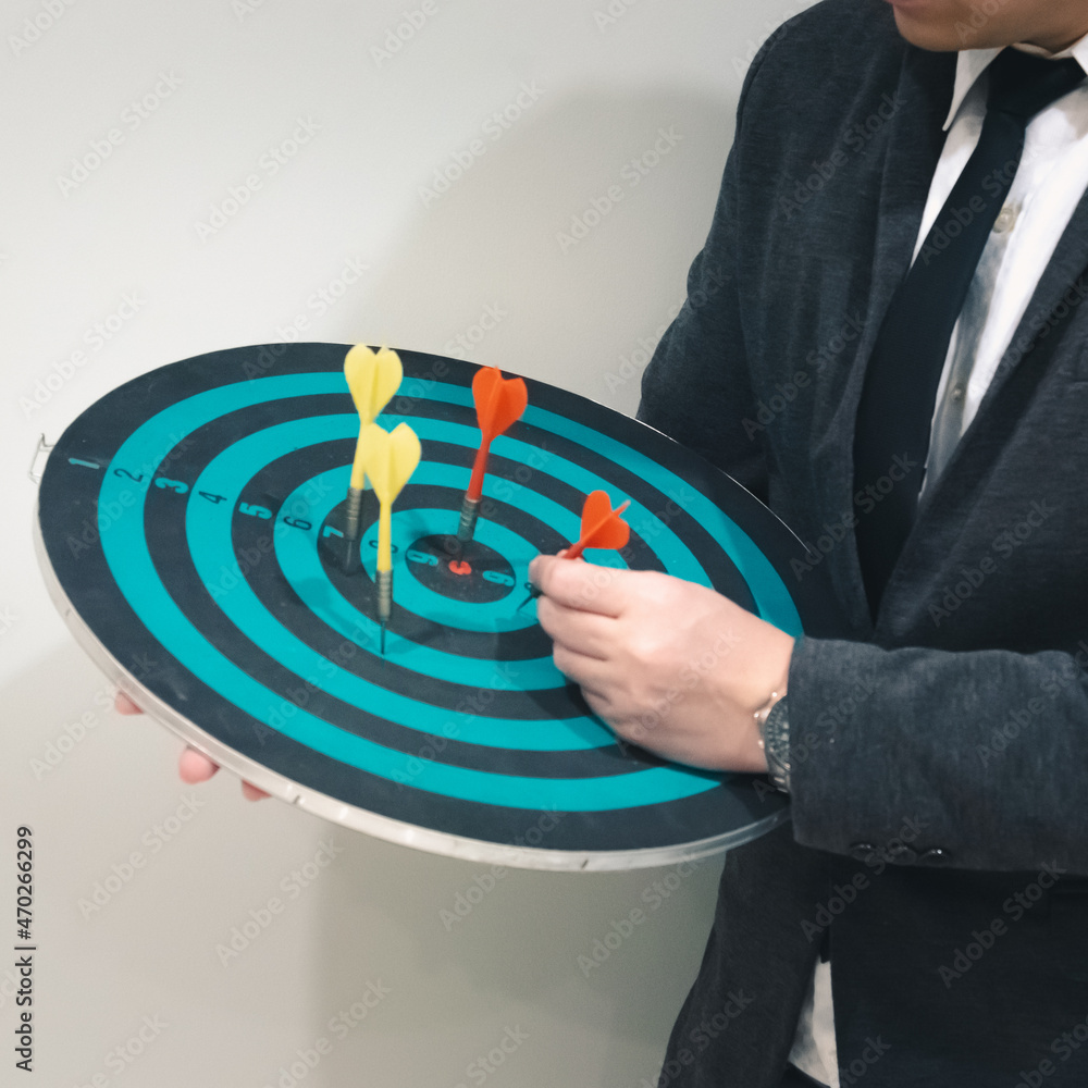Poster close up shot of the dart arrow hit on bulleyes of dartboard to represent that the business reached 