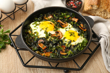 Frying pan with tasty Shakshouka on wooden background
