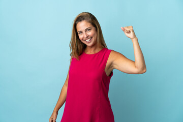 Middle age brazilian woman isolated on blue background doing strong gesture