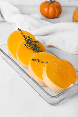 Baking dish with fresh pumpkin pieces on white background