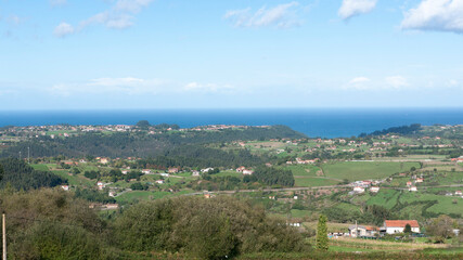 Vista panorámica de valle verde y horizonte marino en Asturias