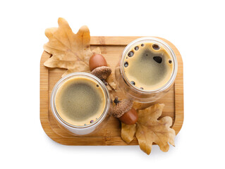 Glass cups of coffee with acorns and autumn leaves on white background