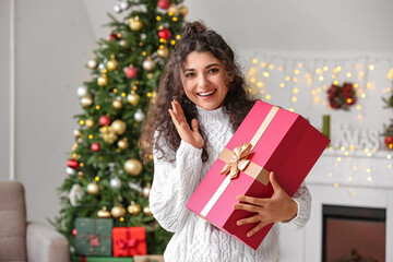 Obraz na płótnie Canvas Happy woman with Christmas gift at home