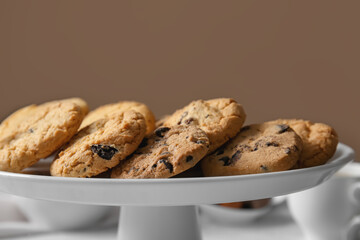 Stand with tasty homemade cookies on brown background, closeup