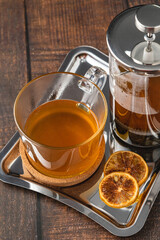 Hot winter tea served with a french press on a wooden floor.