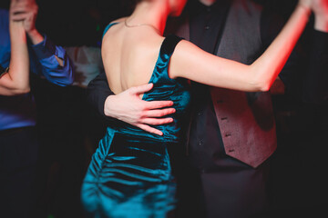Fototapeta premium Couples dancing traditional latin argentinian dance milonga in the ballroom, tango salsa bachata kizomba lesson in the red lights, dance festival