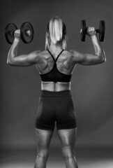 Fototapeta na wymiar Female bodybuilder working out, black and white
