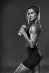 Fototapeta premium Female bodybuilder working out, black and white