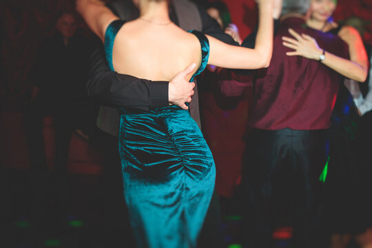 Couples dancing traditional latin argentinian dance milonga in the ballroom, tango salsa bachata kizomba lesson in the red lights, dance festival