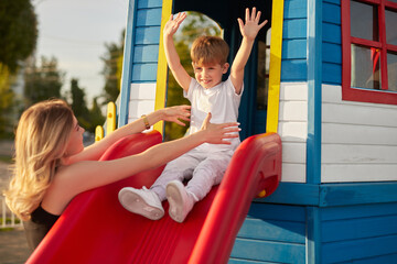 Fototapeta na wymiar Mother and son playing on playground
