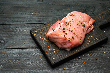 a piece of meat on a cutting board with seasoning