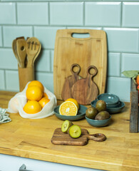 Auswahl an Obst auf Frettchen, in verschiedenen Schalen und Tellern auf Holzuntergrund mit Fliesenspiegel. Gesunde, vitaminreiche, vegane Ernährung, ethisch nachhaltiger Lebensstil, umweltfreundlich, 