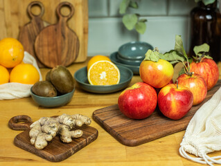 Auswahl an Obst auf Frettchen, in verschiedenen Schalen und Tellern auf Holzuntergrund mit Fliesenspiegel. Gesunde, vitaminreiche, vegane Ernährung, ethisch nachhaltiger Lebensstil, umweltfreundlich, 