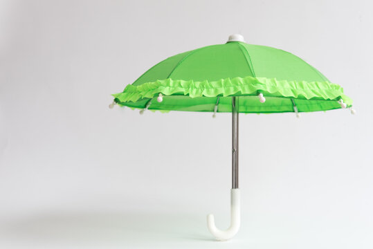 Green umbrella on a white background. Protection and safety concept