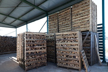 Natural wooden background of chopped firewood in wooden boxes in a warehouse on the street. Firewood stacked and prepared for winter Pile of wood logs