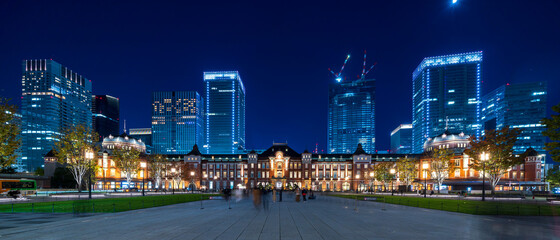 Facade of Tokyo station and business buildings at night.