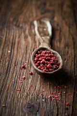 Red pepper on an ceramic spoon over wooden backround