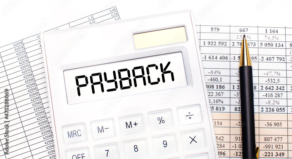 Poster on the desktop there are reports, a white calculator with the text payback on the scoreboard and a p