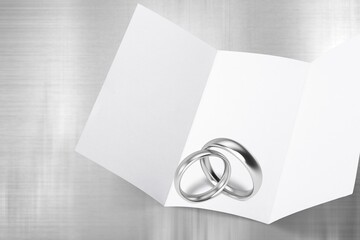 Two wedding rings on a blank marriage contract at a traditional wedding.