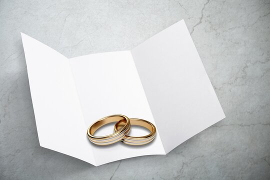 Two wedding rings on a blank marriage contract at a traditional wedding.
