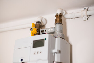 Gas meter measures gas consumption. Gas meter on home indoor wall. High domestic energy prices concept.