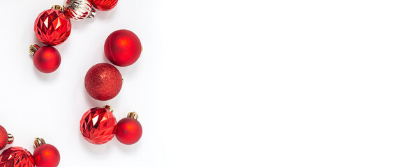 Decorative red balls on a white background. Top view, flat lay. Banner.