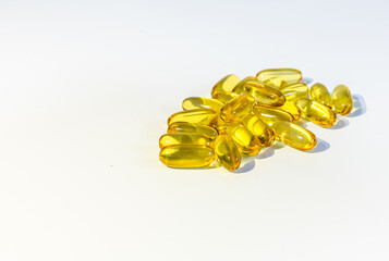 Close up yellow gel capsules with Omega 3 on the white background. oil caps, vitamin, suplements