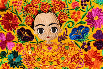 A colorful fabric from a bag from Chiapas, Mexico. Indigenous girl with flowers of various colors on yellow background