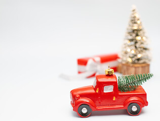 Christmas and New Year background with a red christmas truck and christmas three on a white background