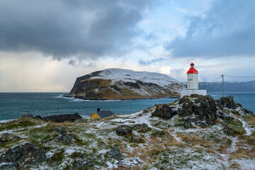 Sturmfront bei Kamøyvær auf Magerøya, mit der Insel Gáhpesuolu. Wilde, steinige Küste mit rot...