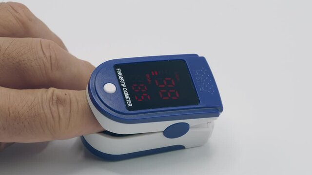 On-finger pulse oximeter displaying oxygen saturation and heart rate