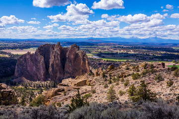 Amazing landscape. Beautiful rocks in the foreground. Colorful valley between the mountains. High mountains with snow on the horizon. Smith Rock state park, Oregon