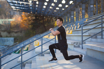 young active asian fit man engaged in physical exercise stretching outdoor street. Male athlete in sportswear workout urban city stadium Healthy Lifestyle Sports fitness outside Warm-up before jogging